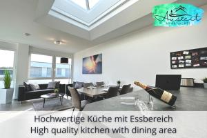 una sala de estar con una cocina de alta calidad con zona de comedor en Auszeit Apartment SUNSHINE am Uferpark - nur 100 m bis zum Bodensee, direkt am Bodenseeradweg, 2 Schlafzimmer, 2 sonnige Dachterrassen, schnelles WLAN, kostenloser Tiefgaragenstellplatz, für bis zu 4 Personen, en Friedrichshafen