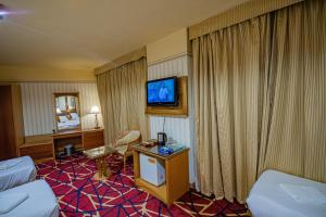 een hotelkamer met een bed en een tv aan de muur bij فندق مسك ام القرى Misk Umm Al Qura Hotel in Mekka