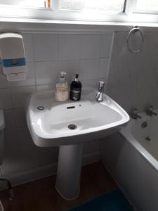 a white sink in a bathroom with a window at Beautiful Private Rooms in London Central Willesden Green in London