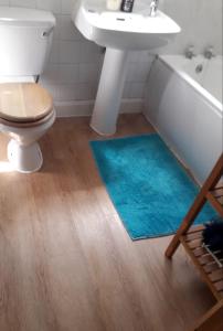 a bathroom with a tub and a sink and a blue rug at Beautiful Private Rooms in London Central Willesden Green in London