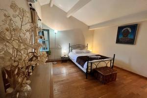 a bedroom with a bed and a plant at L'Ilot Littré-coeur de ville avec balcon in Nîmes