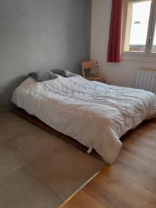duże łóżko w sypialni z oknem w obiekcie Studio du lac bleu w mieście Morillon