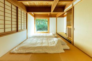 a room with two beds in it with a window at 木木木木 KIGI MOKU MOKU in Sasebo