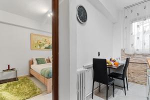 Schlafzimmer mit einem Bett und einem Tisch mit Stühlen in der Unterkunft Central Studio Emerald in Bukarest