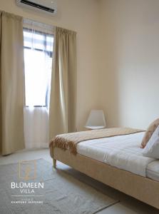 a bedroom with a bed and a window at Blumeen Villa 2 in Kuala Terengganu