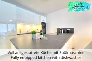 - une cuisine avec un comptoir dans une pièce dans l'établissement Auszeit Apartment SMILE am Uferpark - nur 100 m bis zum Bodensee, direkt am Bodenseeradweg, 2 Schlafzimmer, 2 Sonnenbalkone, schnelles WLAN, kostenloser Tiefgaragenstellplatz, für bis zu 4 Personen, à Friedrichshafen