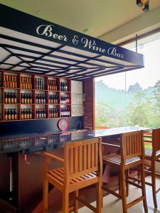 a bar with two chairs and a counter with wine bottles at Delhousie Hotel in Nallathanniya