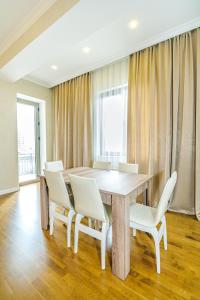 a dining room with a table and white chairs at Buta Palace Luxury House in Baku