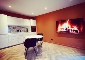 a kitchen with a table and a fire in the wall at Léa Room - Gîte Romantique - Jacuzzi in Bourguébus