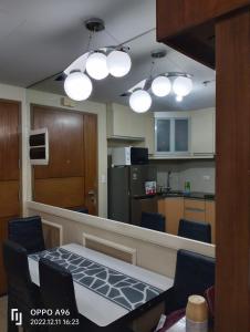 cocina con mesa, sillas y luces en CondoTel Pasay Newport City, en Manila