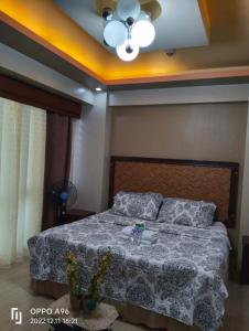een slaapkamer met een bed en een plafondventilator bij CondoTel Pasay Newport City in Manilla