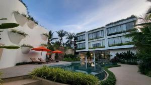 WAKA VILLA Private Resort & Spa - Adults Only في سيام ريب: فندق فيه مسبح ومبنى