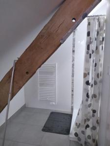 een zolderkamer met een ladder en een raam bij Studio de charme à la campagne in Clayes