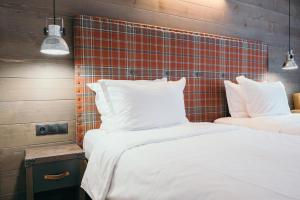 two beds with white sheets and pillows in a room at Iglika Hotel Borovets in Borovets