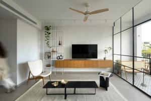 a living room with a television and a chair at Picturesque 3BR Apt w Panoramic Views in Tel Aviv by Sea N' Rent in Tel Aviv