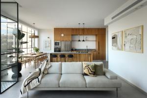 a living room with a couch and a kitchen at Picturesque 3BR Apt w Panoramic Views in Tel Aviv by Sea N' Rent in Tel Aviv