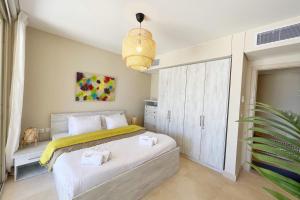a bedroom with a large white bed with towels on it at Sparky & Summery 2 BDR Mangroovy Free Beach & Pool Access in Hurghada