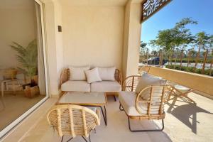 a porch with wicker chairs and a couch at Sparky & Summery 2 BDR Mangroovy Free Beach & Pool Access in Hurghada