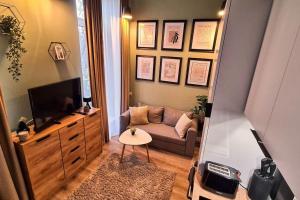a living room with a couch and a television at Downtown studio-loft in Constanţa