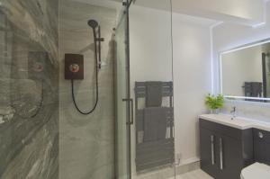 a bathroom with a shower and a sink at Harbour Heights, Luxury Coastal Apartment in The English Riviera, close to the Shops, Bars, Restaurants, Marina and Beaches in Torquay +10 photos
