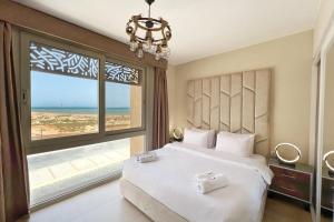 sypialnia z łóżkiem i widokiem na plażę w obiekcie Charming 2BDR w Sea & Pool View Free Beach & Pool Access w mieście Hurghada