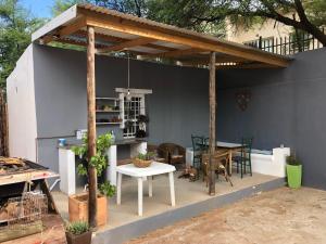 a pergola with a table and chairs and a table and a tableablish at @19 Queenstreet in Calitzdorp