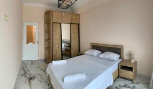 a bedroom with a large white bed with a mirror at City Central Apartment in Yerevan
