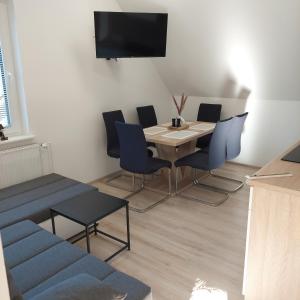 - une salle à manger avec une table, des chaises et une télévision dans l'établissement Apartmaji Biseri, à Kranjska Gora