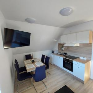 克拉尼斯卡戈拉Apartmaji Biseri的一间带桌椅的厨房和一间带白色橱柜的厨房