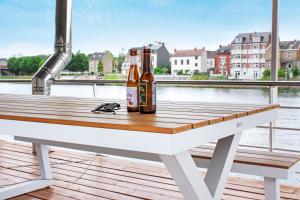 two bottles of beer sitting on a table on a dock at Arcadia - Péniche de Standing à Namur avec vue sur la Citadelle in Namur