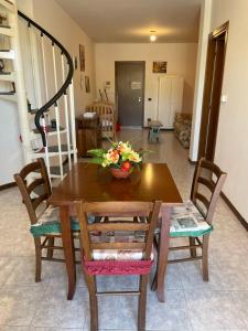 una mesa de madera y sillas con un jarrón de flores. en Casa Molinara, en Negrar