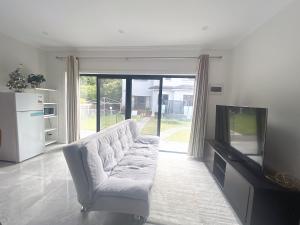 a living room with a couch and a television at Entire new granny flat with 3 bedrooms 2 bathrooms in Sydney