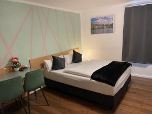 Schlafzimmer mit einem Bett und einem Tisch mit Stühlen in der Unterkunft Residenz Hotel Wuppertal in Wuppertal