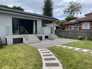 a house with a glass entrance to a yard at Entire new granny flat with 3 bedrooms 2 bathrooms in Sydney