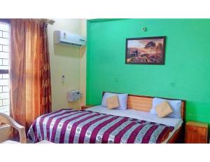1 dormitorio con 1 cama con pared verde en AR Resort & Restaurant, Gauchar, en Chutwāpīpal