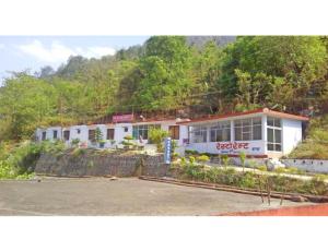 un edificio en una colina al lado de un estacionamiento en AR Resort & Restaurant, Gauchar, en Chutwāpīpal