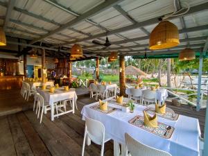 a restaurant with white tables and chairs and lights at Koh Sdach Resort in Kaoh Sdach