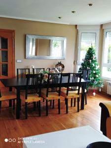 - une salle à manger avec un arbre de Noël, une table et des chaises dans l'établissement Magnificas vistas Alto de Laredo, à Laredo