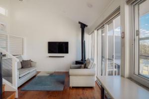 a living room with a tv and a couch and a chair at Wine Country Villas in Pokolbin