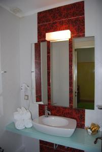 a bathroom with a sink and a mirror and towels at Room "honeybee" in a neoclassical house in Kastoria