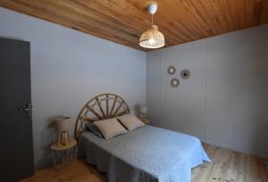 sypialnia z łóżkiem i drewnianym sufitem w obiekcie Chalet de montagne w mieście Formiguères