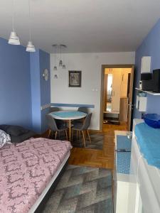 um quarto com uma cama e uma mesa com cadeiras em Luxury apartments Free Parking em Niš