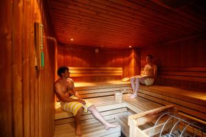 Dois homens estão sentados numa sauna. em Hotel Jakob em Fuschl am See