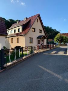 a house with a fence on the side of a road at Ferienwohnung Frieda Thüringen in Brotterode-Trusetal