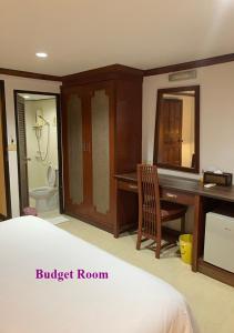 a bedroom with a bed and a desk and a bathroom at Le Tanjong House in Patong Beach