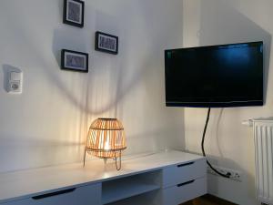 a television on a wall with a lamp on a desk at Ferienwohnung Frieda Thüringen in Brotterode