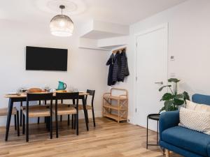 a dining room with a table and chairs and a tv at Driftwood in Newquay