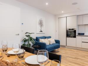 a living room with a table and a blue couch at Driftwood in Newquay