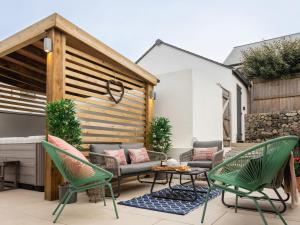a patio with two chairs and a table and chairs at Driftwood in Newquay