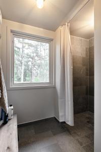 uma casa de banho com um chuveiro e uma janela em Luxury family home near the water for eight people em Estocolmo